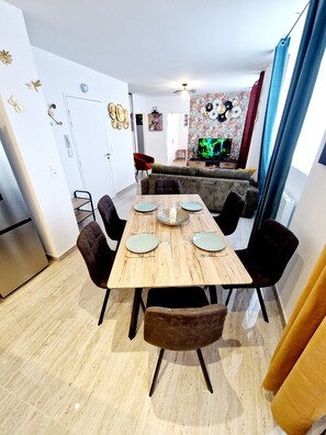 Enjoy meals in this dining area with a table for four, a sofa, and a mounted TV.