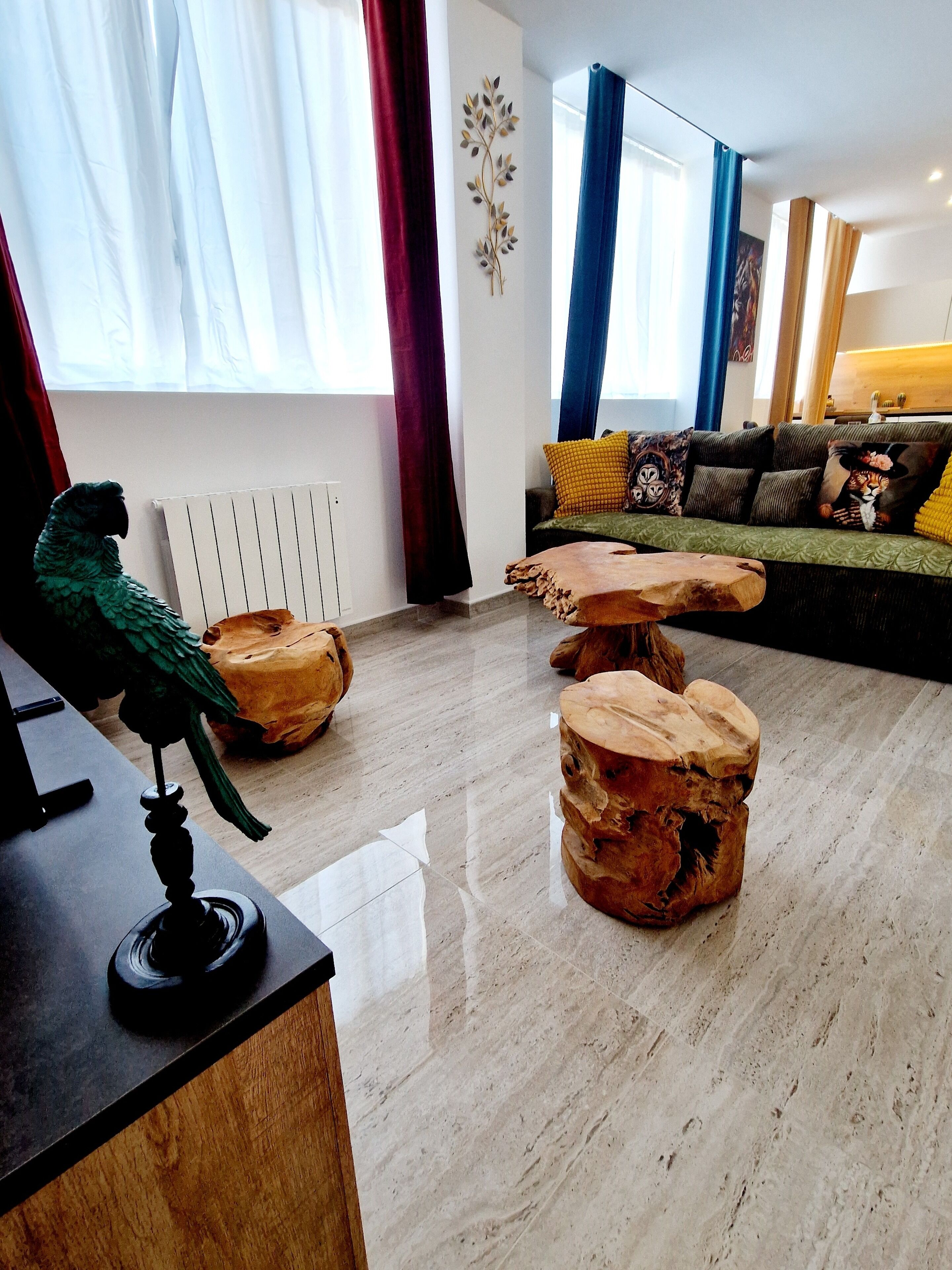 Een moderne woonkamer met een houten salontafel, een bank met gestreepte kussens en een decoratief beeld van een vogel.