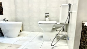 Une salle de bain moderne équipée de toilettes, d’un bidet et d’une douche.