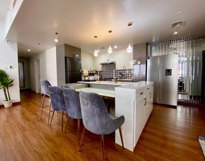 Una cocina moderna con una isla central, electrodomésticos de acero inoxidable y un salpicadero a cuadros.