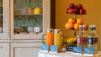 Un assortiment de produits pour le petit-déjeuner comprenant des fruits, du jus et de l’eau en bouteille.