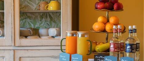 A breakfast display with fruit, juice, and bottled water.