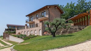 Ein mehrstöckiges Haus mit Backsteinfassade, mehreren Balkonen und einem gepflegten Rasen.