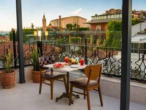 A balcony with a table and two chairs, overlooking a cityscape with buildings and a tower. - Grand Ambiance Hotel (Istanbul)