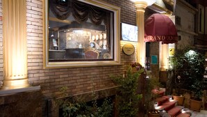 A hotel lobby with a large window, a clock, and a sign for Grand Ambiance Hotels. - Grand Ambiance Hotel (Istanbul)