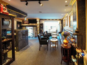 A hotel lobby with a reception desk, seating area, and a view of the street. - Grand Ambiance Hotel (Istanbul)