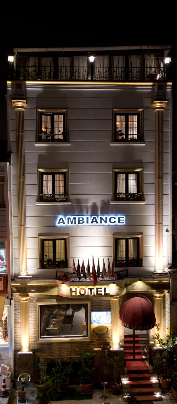 A hotel named "Ambiance" with a classic facade, multiple windows, and a prominent entrance with a red carpet leading to the doors. - Grand Ambiance Hotel (Istanbul)