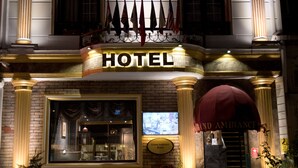 A hotel facade with a prominent "HOTEL" sign, a balcony with flags, and a "Grand Ambiance Hotels" plaque. - Grand Ambiance Hotel (Istanbul)
