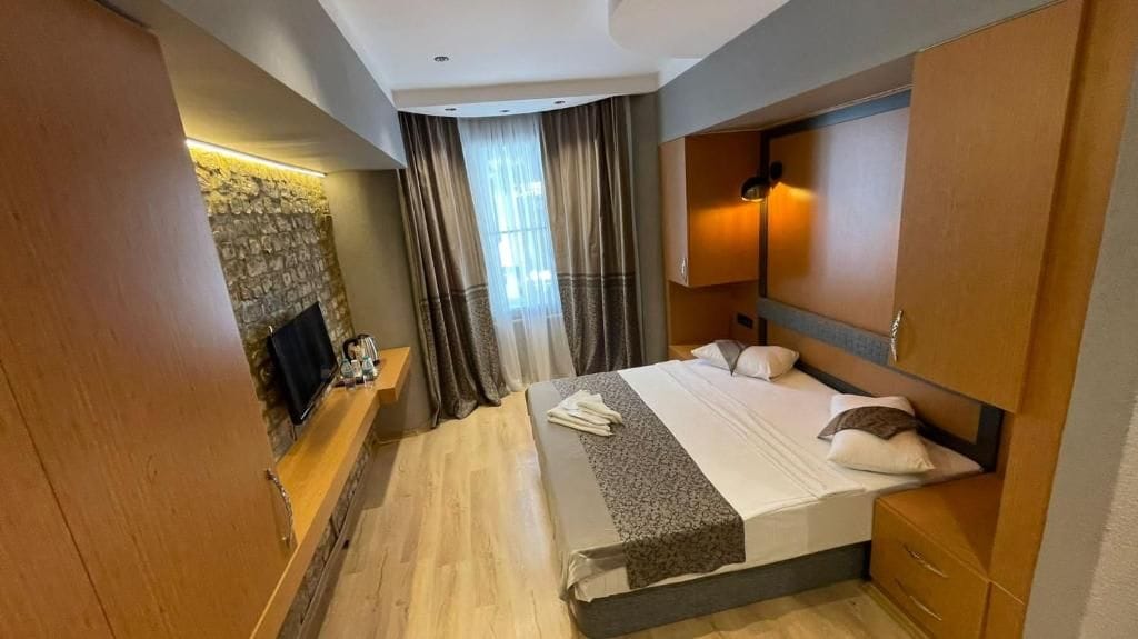 Une chambre d’hôtel équipée d’un lit, d’une télévision, d’une cheminée et d’une armoire.