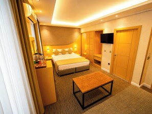 A hotel room with a bed, a desk, a television, and a wardrobe. - Grand Ambiance Hotel (Istanbul)