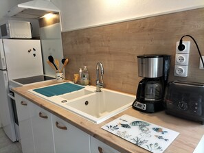 Enjoy cooking in this kitchen with a central sink, coffee maker, toaster, microwave, and refrigerator.