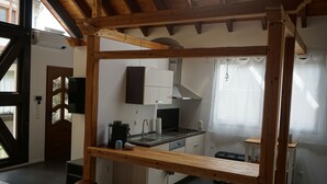 A compact kitchen with wooden beams, a built-in dishwasher, and a window overlooking the room. - The very special vacation apartment (Bingen am Rhein)
