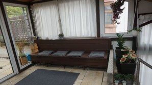 A room with a wooden bench, a black mat, and potted plants. - The very special vacation apartment (Bingen am Rhein)