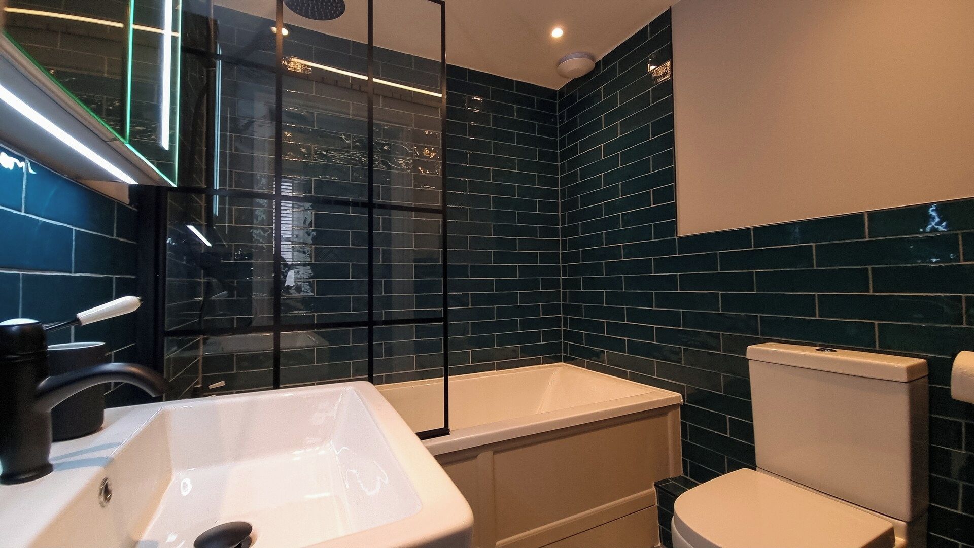 Un bagno moderno con vasca, WC e lavandino.