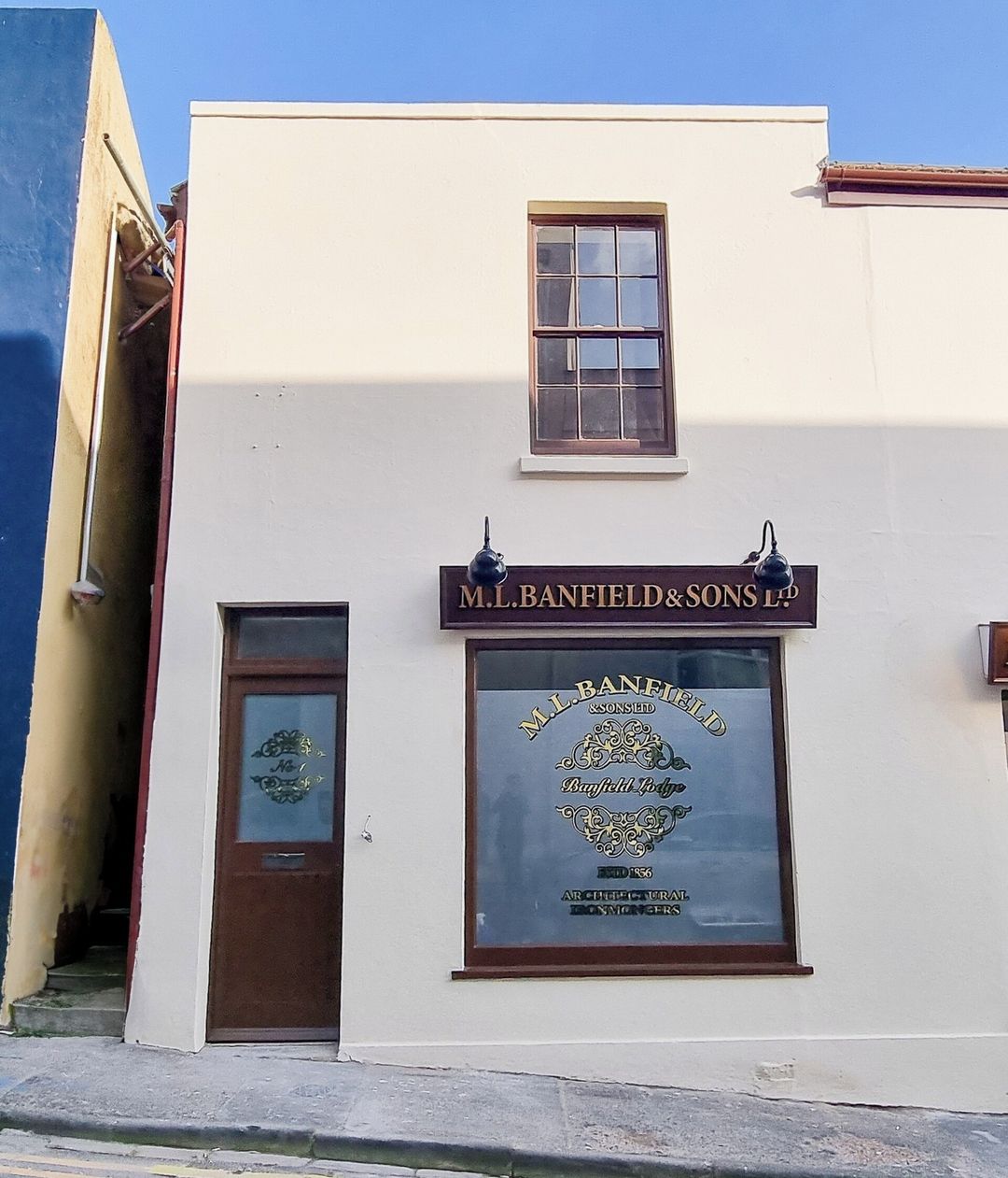 A building with a sign that reads 'M.L. BANFIELD & SONS LTD.' and a window with a logo.