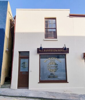 A building with a sign that reads 'M.L. BANFIELD & SONS LTD.' and a window with a logo.