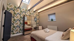 A bedroom with a bed, a mirror, a window, and a radiator.