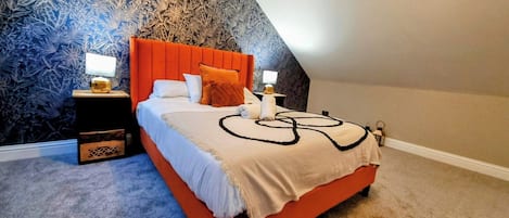 Un dormitorio con cama, mesitas de noche y un papel tapiz decorativo.