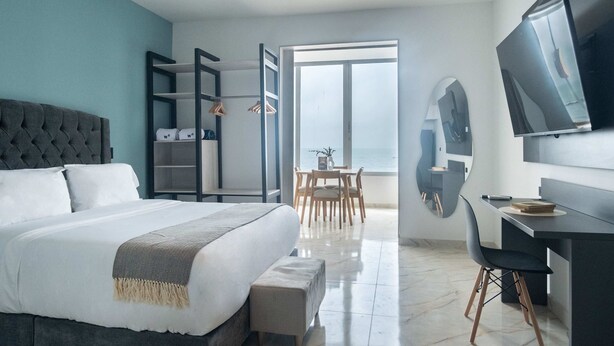 Een moderne slaapkamer met een groot bed, een bureau en een televisie.