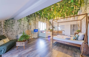 Una sala de estar moderna con un sofá, una mesa de centro con plantas, un televisor y una pared de plantas colgantes única.