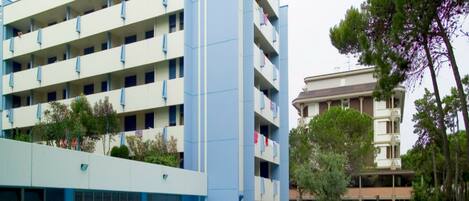 A hotel with multiple floors, a swimming pool, and a garden area.