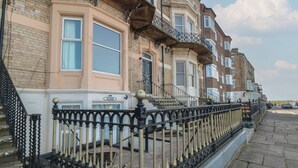 Une rangée de maisons mitoyennes, avec une clôture en fer noir au premier plan.