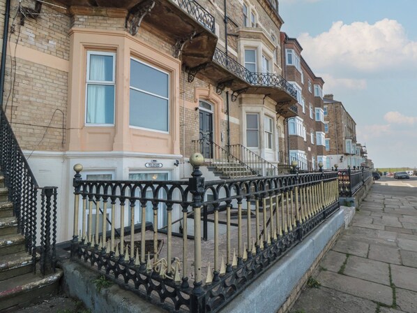 A row of terraced houses with a black iron fence in the foreground.