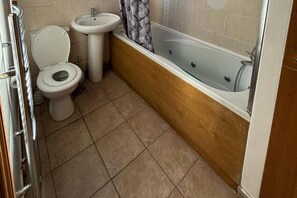 Kombinert dusj/badekar, dype avslapningsbadekar og håndklær