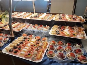 A buffet table with various desserts and pastries.