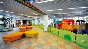 Uma área de recreação infantil com assentos coloridos e estruturas de lazer.