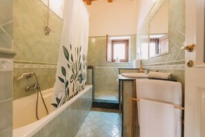 A bathroom with a bathtub, a sink, and a window. - Loft by Melo - Seaview terrace (Siracusa)