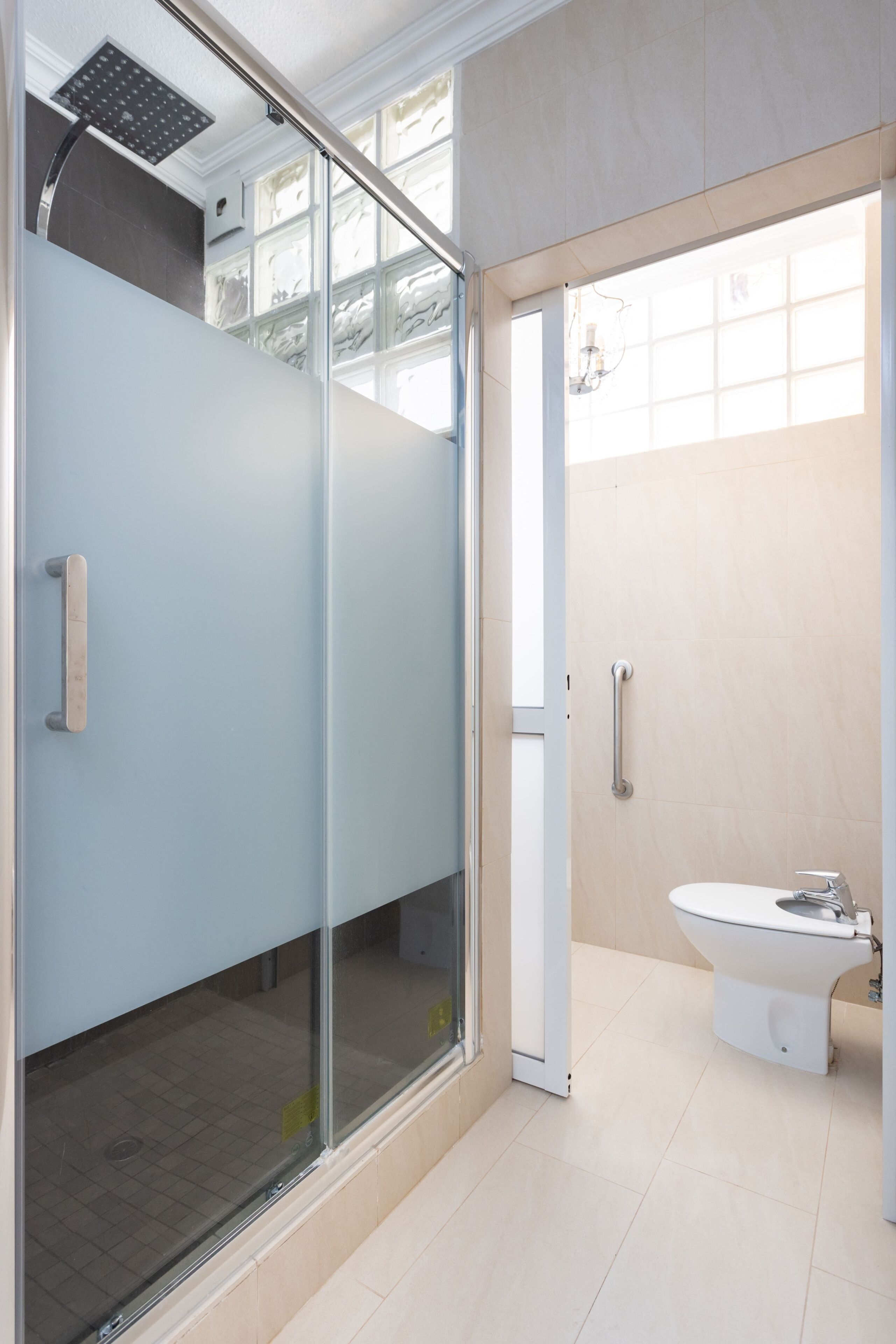 Un baño moderno con cabina de ducha de vidrio, inodoro y lavabo.