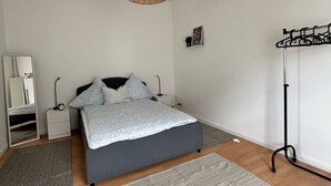 Une chambre à coucher avec un lit, une table de chevet, une lampe et un luminaire suspendu.