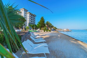 Accommodatie ligt op het strand, ligstoelen, parasols, strandlakens