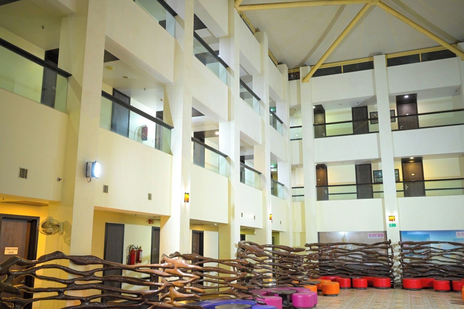 A multi-level atrium with a central staircase, glass railings, and a fire safety system.