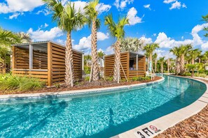 A swimming pool with wooden structures and palm trees. - 16049 Blue Wave Way (Clermont)