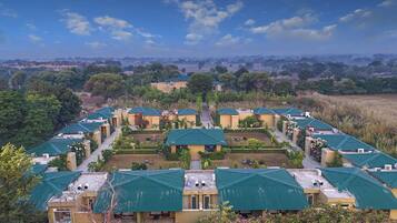A resort with multiple buildings, each with a green roof and surrounded by well-maintained gardens.