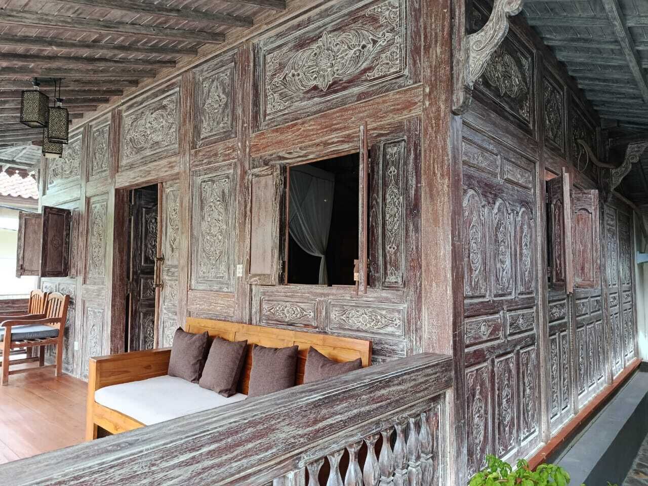 A traditional wooden room with a bed, a bench, and a table.