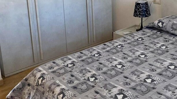 Ein Schlafzimmer mit Bett, Kleiderschrank und Nachttischlampe.
