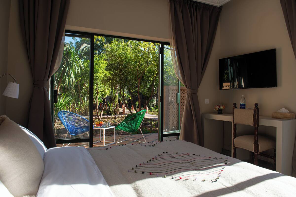 Une chambre à coucher avec un lit, une chaise, un bureau et un téléviseur.