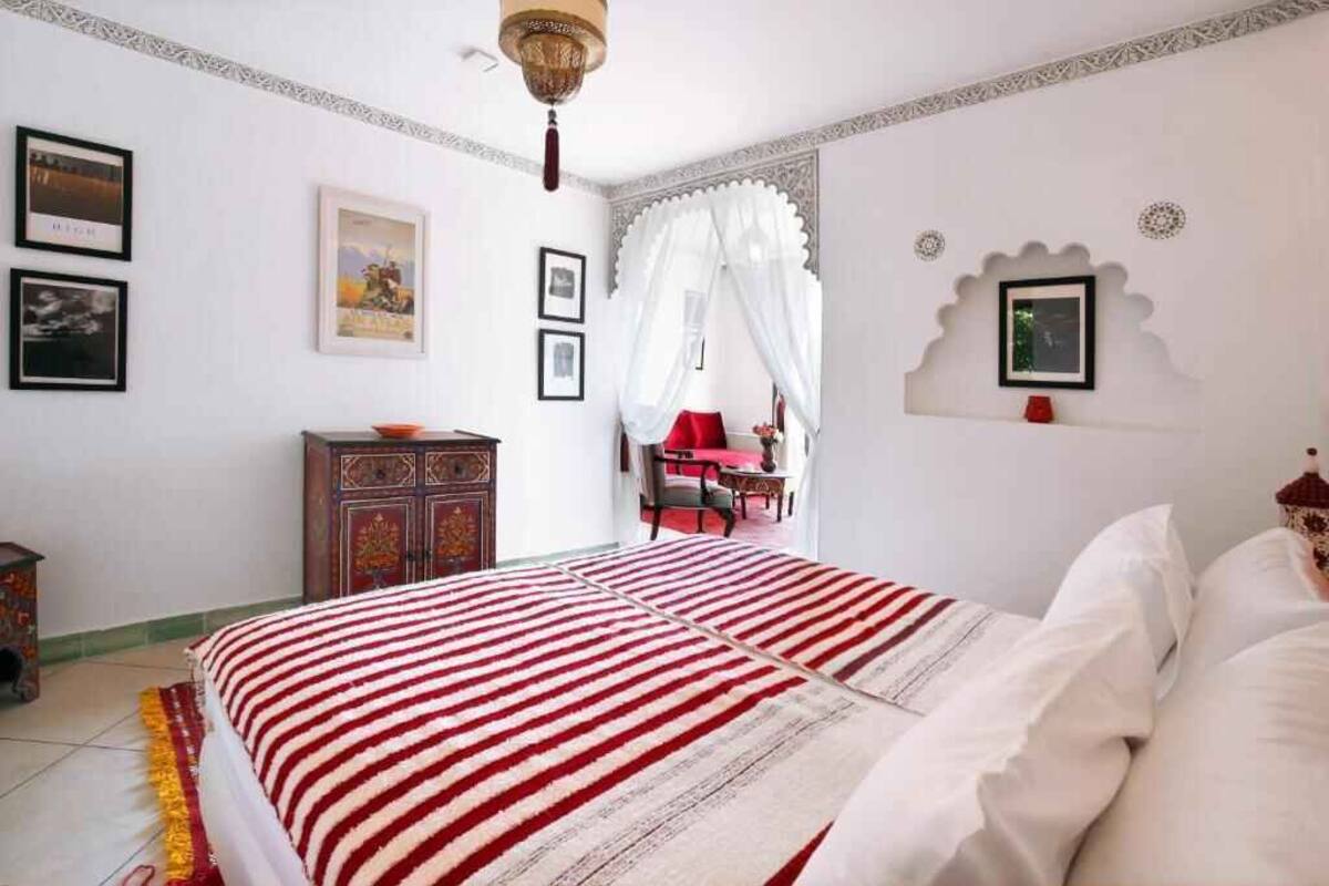 Une chambre à coucher avec un lit, une armoire, une chaise et une table.