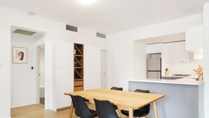 A modern kitchen with white cabinets, a built-in oven, and a countertop. - RARE FIND! Modern 2 Bdrm, 2 Bath, 1 Car in Central Sydney (City of Sydney)