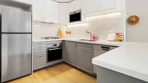 A modern kitchen with stainless steel appliances, grey cabinets, and a white countertop. - RARE FIND! Modern 2 Bdrm, 2 Bath, 1 Car in Central Sydney (City of Sydney)