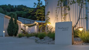 A restaurant sign in a garden setting with a pathway leading to a building. - Laetari Pension, Gyeongju (Gyeongju)