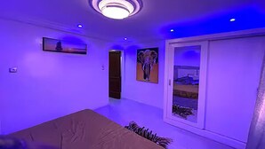 Quarto com cama, guarda-roupa e porta que dá para outro cômodo.