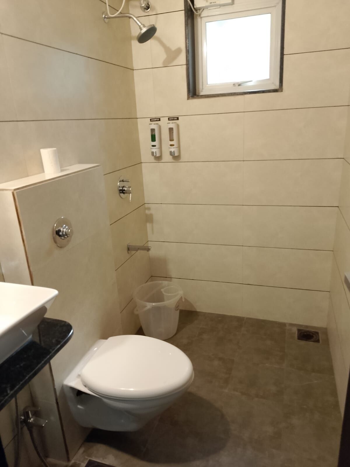 Un baño pequeño y funcional con inodoro, lavabo y ducha.
