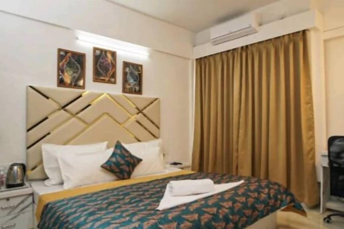 Ein Hotelzimmer mit Bett, Nachttisch, Schreibtisch und Stuhl.