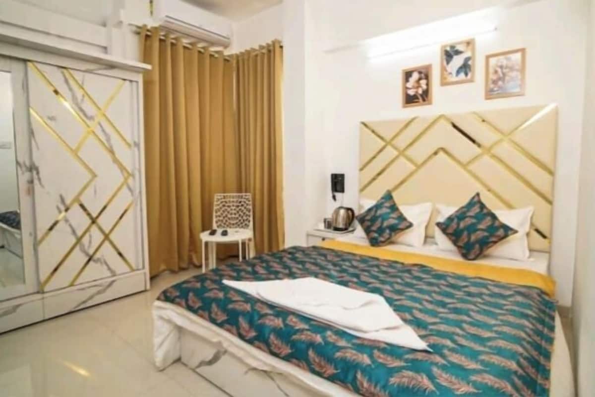 Ein Schlafzimmer mit einem großen Bett, einem Kleiderschrank, einem Sessel und einem Nachttisch.