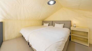 A bedroom with a single bed, a nightstand, and a lamp.
