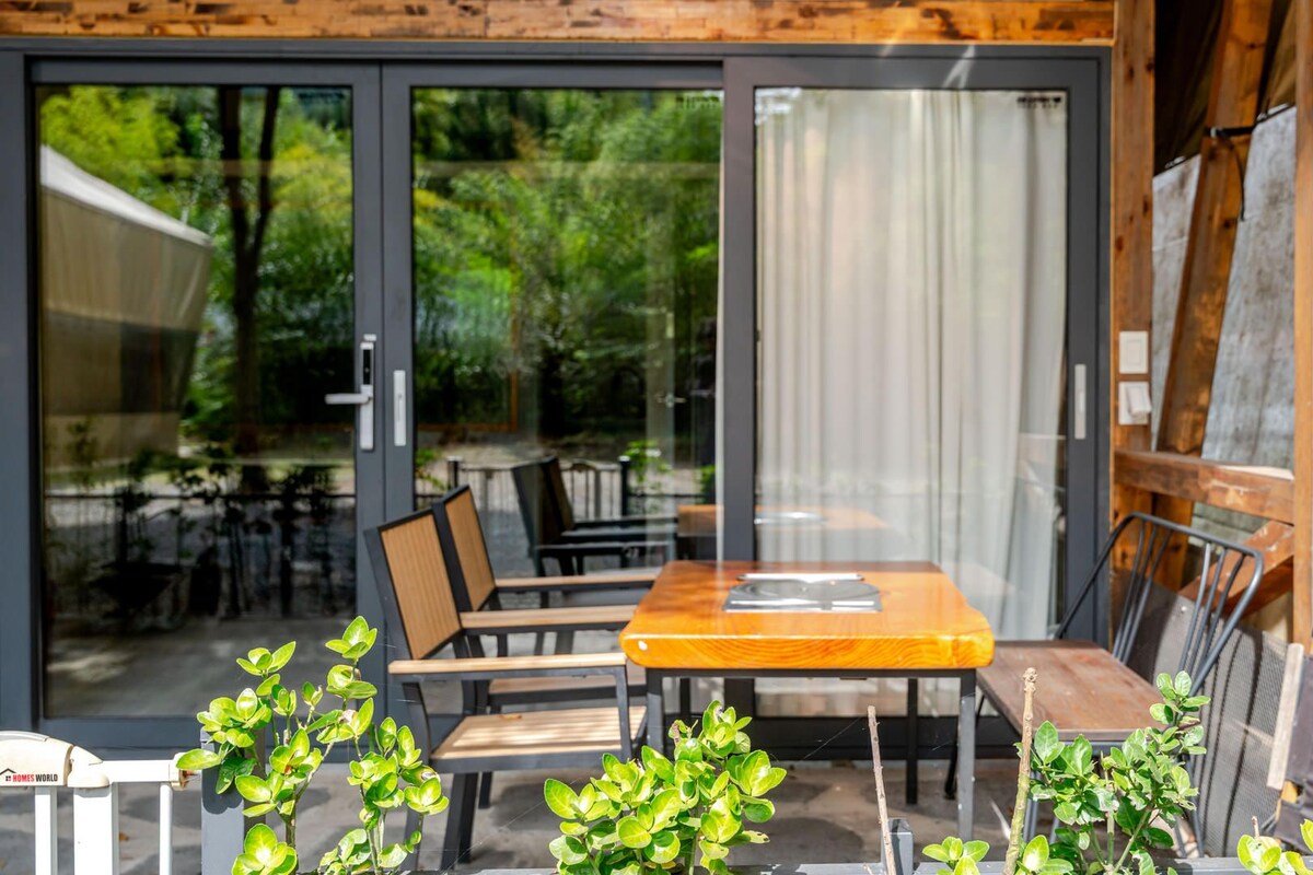 Een terras met een tafel en stoelen, omringd door plantenpotten.